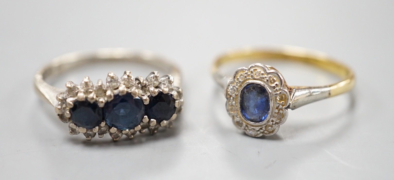 An 18ct white metal, sapphire and diamond set triple cluster ring, size O and a yellow metal, sapphire and diamond set oval cluster ring, size O/P, gross weight 6.8 grams.
